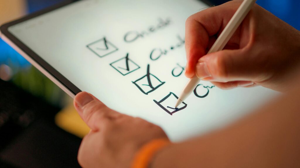 Personne cochant des cases sur une tablette, illustration du questionnaire de diagnostic sécurité informatique TPE-PME